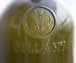 Reliéf v horní části láhve - dva již rozostření vinaři :-) nesou jeden obří velehrozen, pod tímto výjevem je nápis oblasti původu vína - Villány.