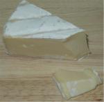 Řez sýrem Ramadet - sýr s bílou plísní na povrchu.